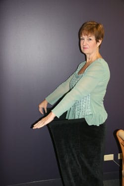 Peggy After 221 pound medical weight loss posing in old pants