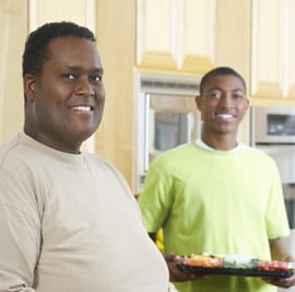2 men one holding plate of healthy food