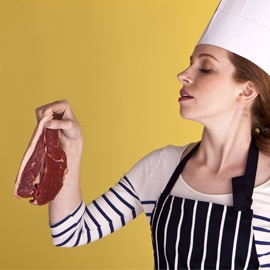 chef holding piece of raw red meat