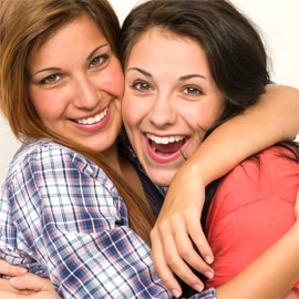 two women friends hugging and smiling