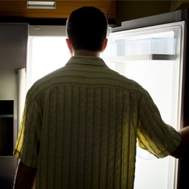 nighttime eating person at refrigerator in dark room