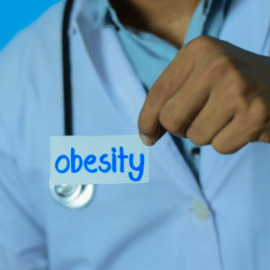 doctor with obesity written on piece of paper