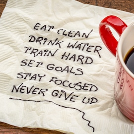 health tips written on napkin eat clean drink water train hard set goals stay focused never give up